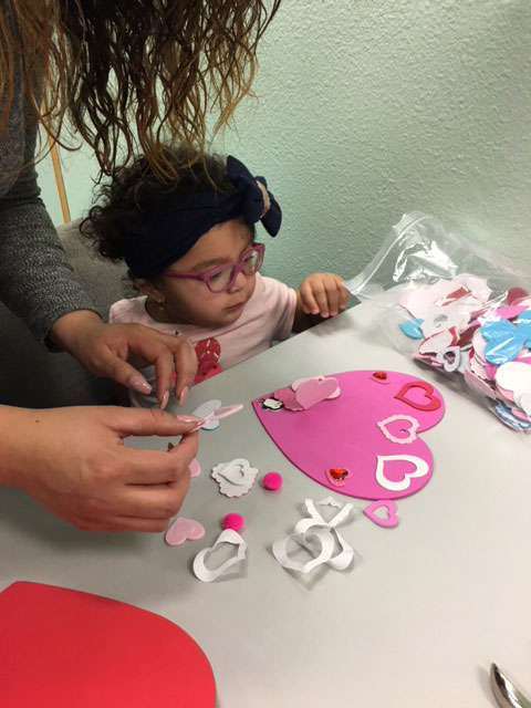 A mother and her child are making a tactile Valentine card